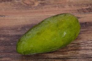 Green tasty mango over wooden background photo