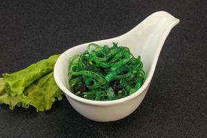 Green Chuka Seaweed Salad Isolated on White Background Top View. Wakame Sea Kelp Salat photo