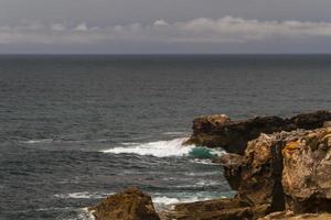 The waves fighting about deserted rocky coast of Atlantic ocean, Portugal photo