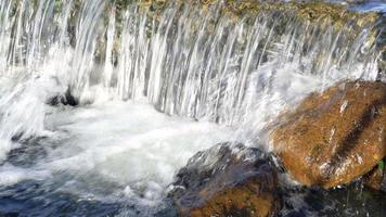 petite chute d'eau coule de la montagne dans un ruisseau video