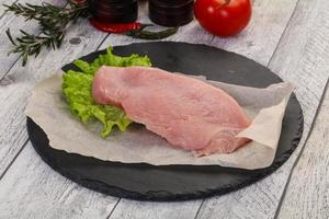 Raw Turkey steak served rosemary photo