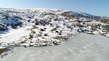 Frozen lake in the plateau. Aerial view of frozen lake in snowy plateau. video