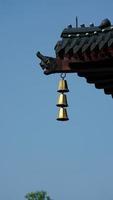 The golden bell hanging on the top of eaves in one temple of the China photo