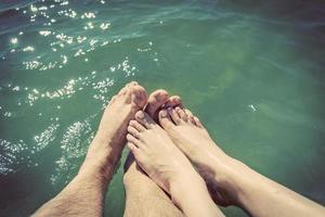 una pareja enamorada mojando sus pies en el mar. vacaciones de verano. antiguo. foto