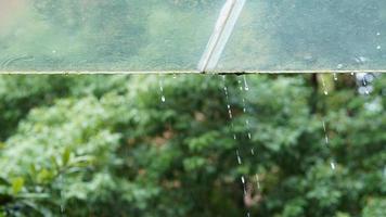 The glass window covered by the rain droplets and waterfall in the rainy day photo