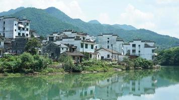 The beautiful Chinese countryside village view with  the old traditional buildings surrounded by the natural environment photo