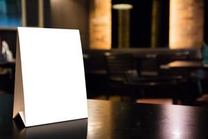 maqueta de marco de menú de etiqueta blanca en la mesa con fondo interior de cafetería restaurante foto