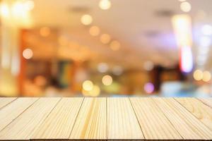 mesa de madera con fondo desenfocado de luces bokeh de restaurante cafetería borrosa abstracta foto