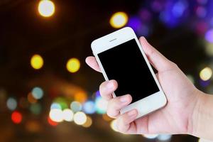 Business concept, hand holding mobile with traffic light blurred background photo