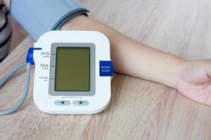 Woman using digital blood pressure monitor photo