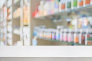 pharmacy store counter table top with blur medicine on shelves photo
