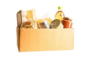 Foodstuff for donation, storage and delivery. Various food, pasta, cooking oil and canned food in cardboard box. photo