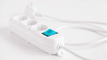 Modern white electric extension cord with a button on a white background photo