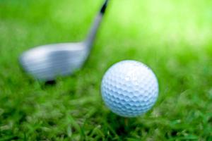 golf ball close-up in soft focus at sunlight with Green grass. wide landscape as background ,Sport playground for golf club concept.shallow focus effect. photo