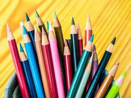 Multicolored pencils are combined in a steel box on a desk in the office. photo