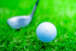 golf ball close-up in soft focus at sunlight with Green grass. wide landscape as background ,Sport playground for golf club concept.shallow focus effect. photo