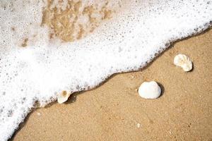 White wave bubble Striking the boulders and brown sand in Cha-am sea, Thailand photo