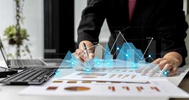 A businesswoman examines data on financial documents, company financial reports, graphics showing financial and numerical growth data. The concept of financial management to grow and be profitable. photo