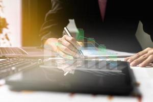 Businesswoman using a tablet to view company financial reports, graphics showing financial and numerical growth data. The concept of financial management to grow and be profitable. photo