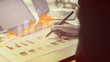 A businesswoman examines data on financial documents, company financial reports, graphics showing financial and numerical growth data. The concept of financial management to grow and be profitable. photo