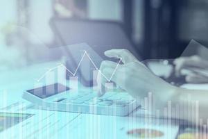 Businesswoman presses a calculator to check data on documents, company financial reports, graphics showing financial and numerical growth data. Financial management to grow and be a profitable concept photo
