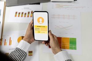 Person holding a mobile phone in the member login screen, a businessman is going to access the company's membership system, check the information of the parties. in the company that is in the system. photo