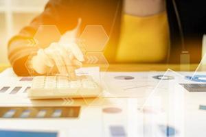 Businesswoman presses a calculator to check data on documents, company financial reports, graphics showing financial and numerical growth data. Financial management to grow and be a profitable concept photo