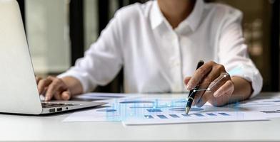 A business man examines data on financial documents, company financial reports, graphics showing financial and numerical growth data. The concept of financial management to grow and be profitable. photo