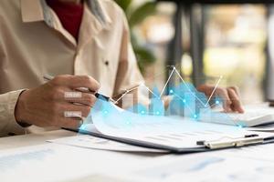 A business man examines data on financial documents, company financial reports, graphics showing financial and numerical growth data. The concept of financial management to grow and be profitable. photo