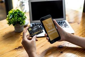 Person holding a smartphone at the screen of an online payment website, using a smartphone to pay for goods via credit card online. Concept of using smartphones to pay for products via credit card. photo