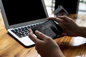 A person holding a smartphone in front of a screen showing a job search service, using the smartphone to search for jobs and apply for jobs through online websites. Concept of using smartphones. photo