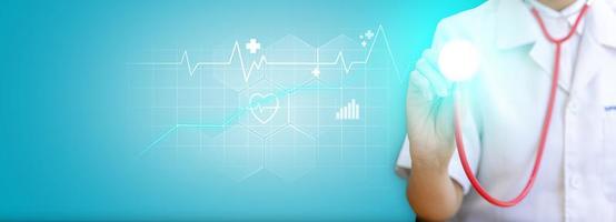 Doctor holding a stethoscope showing a heart wave graphic, line graph, bar graph, heart shape with wave cut in the middle. Modern medical technology concept. Banner background with copy space. photo