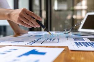 A business man examines data on financial documents, company financial reports, graphics showing financial and numerical growth data. The concept of financial management to grow and be profitable. photo