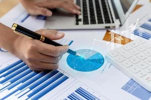 A business man examines data on financial documents, company financial reports, graphics showing financial and numerical growth data. The concept of financial management to grow and be profitable. photo