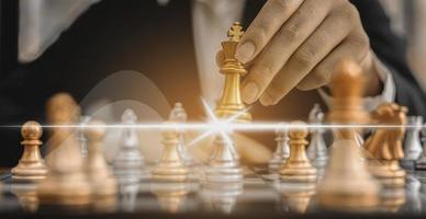 Person holding a chess piece against another opponent's chess, conceptual image of businessman playing chessboard compared to managing a business on risk, chart graphics showing financial flows. photo