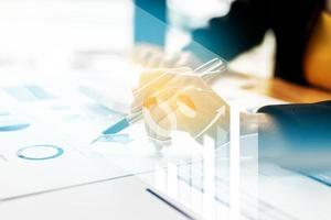 A businesswoman examines data on financial documents, company financial reports, graphics showing financial and numerical growth data. The concept of financial management to grow and be profitable. photo