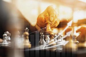 Person holding golden chess pieces to run a game, conceptual image of businessman playing chessboard compared to managing a business on risk, chart graphics showing financial flows. photo