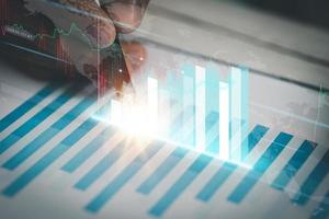 A business man examines data on financial documents, company financial reports, graphics showing financial and numerical growth data. The concept of financial management to grow and be profitable. photo