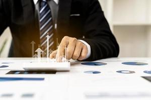 Businesswoman presses a calculator to check data on documents, company financial reports, graphics showing financial and numerical growth data. Financial management to grow and be a profitable concept photo