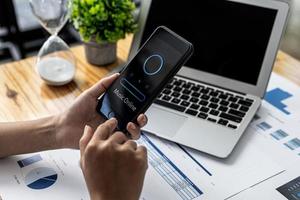 A person holding a smartphone in front of the online music program, using a smartphone to listen to music online via the Internet network. Concept of using smartphones, entertainment media and online. photo