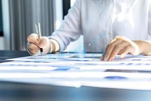 A businesswoman examines data on financial documents, company financial reports, graphics showing financial and numerical growth data. The concept of financial management to grow and be profitable. photo