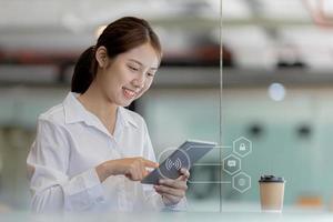 Asian woman using tablet to chat with friends and search web browser using WiFi, showing login icon diagram, chatting on messenger, searching for information through a web browser. Technology concept. photo