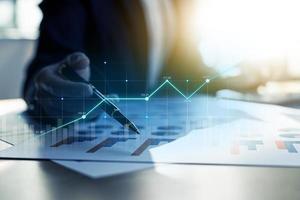 A business man examines data on financial documents, company financial reports, graphics showing financial and numerical growth data. The concept of financial management to grow and be profitable. photo