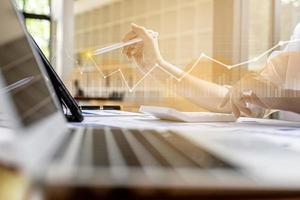 A business man examines data on financial documents, company financial reports, graphics showing financial and numerical growth data. The concept of financial management to grow and be profitable. photo