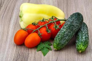 Cucumbers and tomatoes on the branch with yellow pepper photo