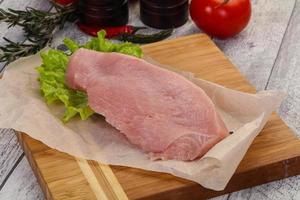 Raw Turkey steak served rosemary photo