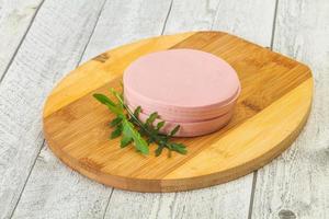 Sliced sausage over the wooden board photo