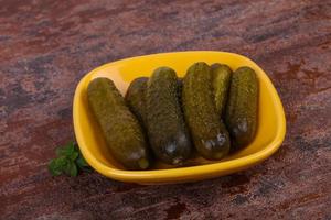 Pickled cucumbers heap in the bowl photo