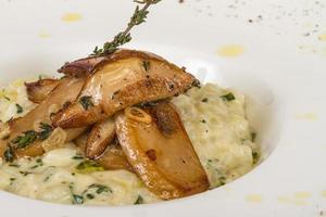 photo of delicious risotto dish with herbs and mushrooms on white background