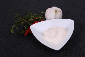 salsa de mayonesa en el tazón blanco servido con tomillo y ajo foto